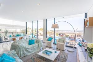 a living room with furniture and a large window at Villa Sao Martinho in São Martinho do Porto