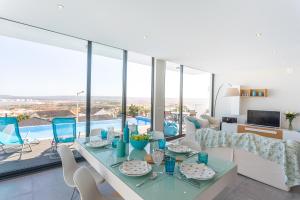a living room with a table and chairs and a pool at Villa Sao Martinho in São Martinho do Porto