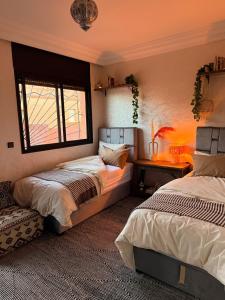 a bedroom with two beds and a window at Charming Bohemian hideaway in Marrakech in Marrakesh