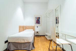 a bedroom with a bed and a glass table at Edificio Fénix by Plaza Mayor Apartamentos in Valladolid