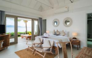 a bedroom with a bed and a living room at Miskawaan Beachfront Villas in Mae Nam