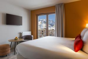 a hotel room with a large bed and a window at SOWELL FAMILY Vars in Vars