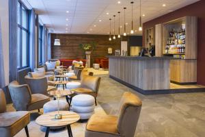 a restaurant with tables and chairs and a bar at SOWELL FAMILY Vars in Vars