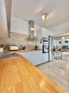 a large kitchen with white cabinets and a wooden floor at Chalet JULI Mirador in Puerto de la Cruz +36 photos