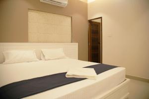 a bedroom with a large white bed with a window at Gentur Enclave in Mananthavady
