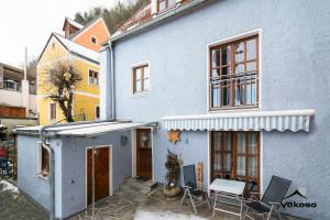 a blue house with a table and chairs in front of it at Naabblick in Kallmünz