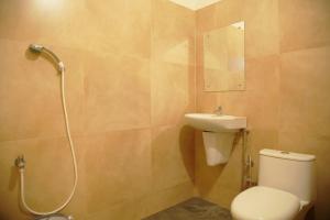 a bathroom with a toilet and a sink and a shower at Gentur Enclave in Mananthavady +10 photos
