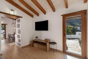 a living room with a tv on a white wall at La Pelusa casa rural in La Culata