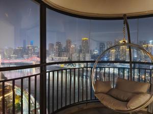 a chair on a balcony with a view of the city at Chihiro Haven in Chongqing