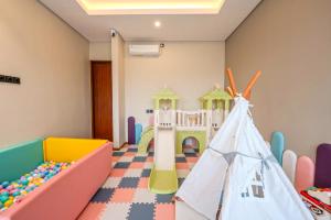 Ein Kinderzimmer mit Spielmöbeln und einem Kinderbett in der Unterkunft Villa Asvari in Tabanan