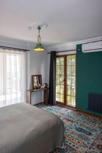a bedroom with a bed and a green wall at Loidevilla in Çamurlu