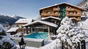 a house with a swimming pool in the snow at L'Hermine Blanche in Morzine