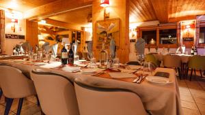 a dining room with a long table and chairs at L'Hermine Blanche in Morzine