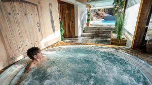 a man in a jacuzzi tub in a backyard at L'Hermine Blanche in Morzine