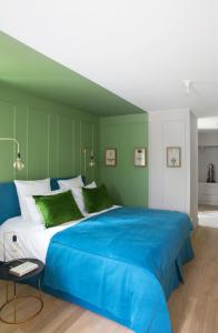a bedroom with a large blue bed with green walls at ANNEXE 1888 in Magland
