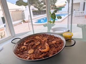 a pan of food sitting on a table with shrimp at Amarella Costa Dorada - Alojamientos privados en villa mediterránea con amplia piscina y zonas BBQ in Les tres Cales