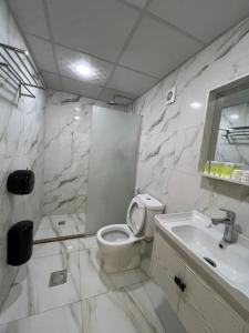 a white bathroom with a toilet and a sink at Tamim Luxury wadi rum camp in Wadi Rum +105 photos