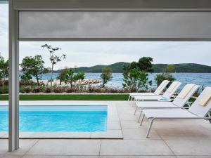 a group of lounge chairs sitting next to a swimming pool at Sibenik Resort in Šibenik
