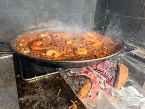 a bunch of food cooking in a pan on a grill at Amarella Costa Dorada - Alojamientos privados en villa mediterránea con amplia piscina y zonas BBQ in Les tres Cales