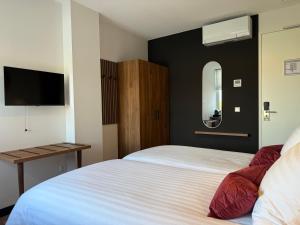 a hotel room with two beds and a mirror at Zen Kitchen & Boutique Hotel in Brouwershaven
