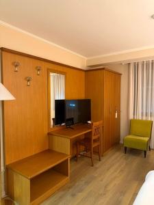 a hotel room with a desk and a television at Arber Hotel in Tirana
