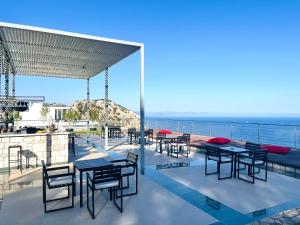 a patio with tables and chairs and the ocean at Loryma Resort Hotel in Turunç