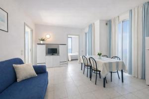 a living room with a table and a blue couch at AMA Marena Apartments in Pesaro