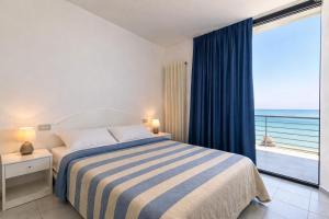 a bedroom with a bed with a view of the ocean at AMA Marena Apartments in Pesaro