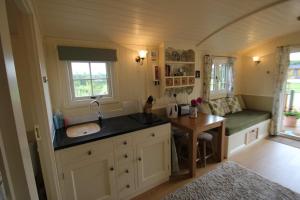 a kitchen with a sink and a bench in a room at Le Grande Roulotte in Hassocks