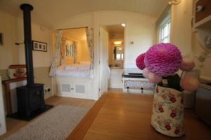 a vase with flowers in a room with a fireplace at Le Grande Roulotte in Hassocks