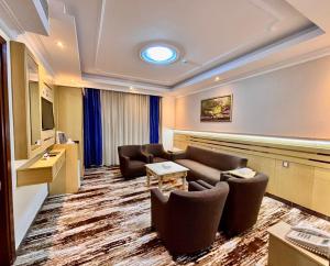 a hotel room with couches and a flat screen tv at فندق مواسم الاحسان توصيل مجانى للحرم in Al ‘Azīzīyah
