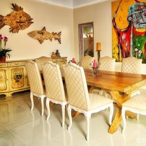 een eetkamer met een houten tafel en stoelen bij Bamboo Moon Villas in Sanur