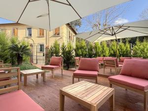 a patio with chairs and tables and umbrellas at Palazzo Garbusi in Sarzana
