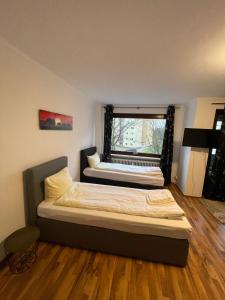 a bedroom with two beds and a window at Studio Apartment mit Balkon in Neumünster