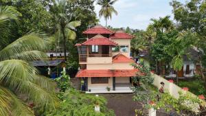an image of a house with a red roof at Atharvam Resort in Cherai Beach