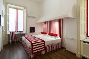 a bedroom with a large bed with red pillows on it at Otium in Sorrento in Sorrento