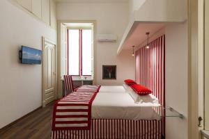 a bedroom with a bed with red pillows on it at Otium in Sorrento in Sorrento +7 photos