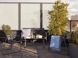 a patio with a table and chairs on a roof at YAYS Paris Issy by Numa in Issy-les-Moulineaux +32 photos