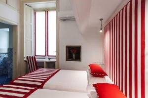 a bedroom with a white bed with red pillows at Otium in Sorrento in Sorrento