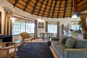 ein Wohnzimmer mit Sofa und Tisch in der Unterkunft Sable Ranch Selfsorg in Brits
