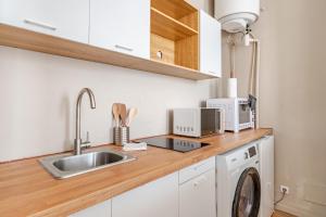 a kitchen with a sink and a washing machine at Charmant Studio Cosy - Hyper-Centre D'Elbeuf in Elbeuf +2 photos