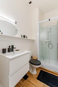 a white bathroom with a toilet and a glass shower at Charmant Studio Cosy - Hyper-Centre D'Elbeuf in Elbeuf