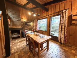 a dining room with a table and a fireplace at LA POMME DE PIN 1 Appartement avec terrasse in La Bresse