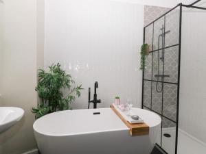 a white bathroom with a tub and a sink at The Wonky Nest in Windermere +34 photos