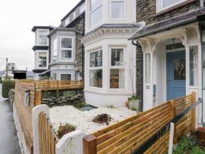 a house with a blue door and a wooden fence at The Wonky Nest in Windermere
