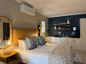 a bedroom with a large white bed with blue walls at The Blossom Room in Robertson