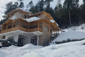 eine Blockhütte im Schnee mit in der Unterkunft Forest Nook in Manali