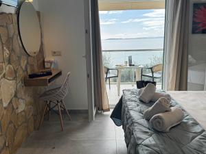 a bedroom with a bed with a view of the ocean at Vladimiros Apartments in Barbati