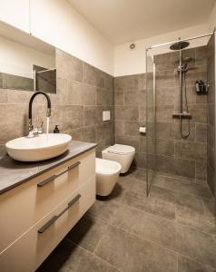 a bathroom with a sink and a toilet and a shower at Chesa Sarvit in Celerina