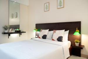 a bedroom with a large bed with white sheets and pillows at โรงแรมสินสิริ ปัญญา-รามอินทรา in Bangkok